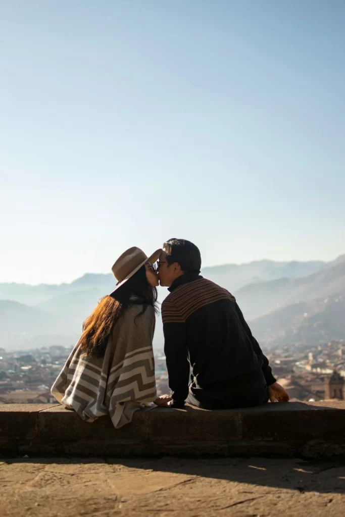 Romantic couple kissing at San Cristóbal viewpoint in Cusco, overlooking the historic city during their Peru honeymoon.