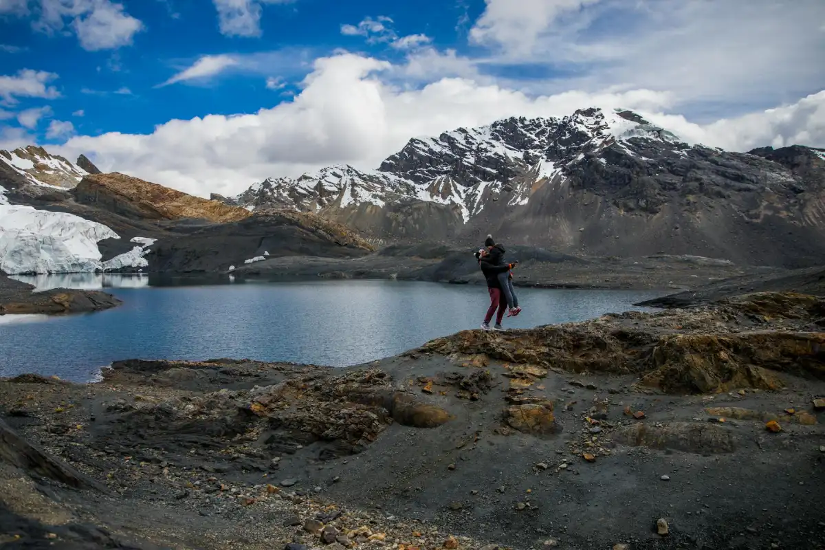 Couple embracing at a scenic Andean lake during their romantic getaway in Peru