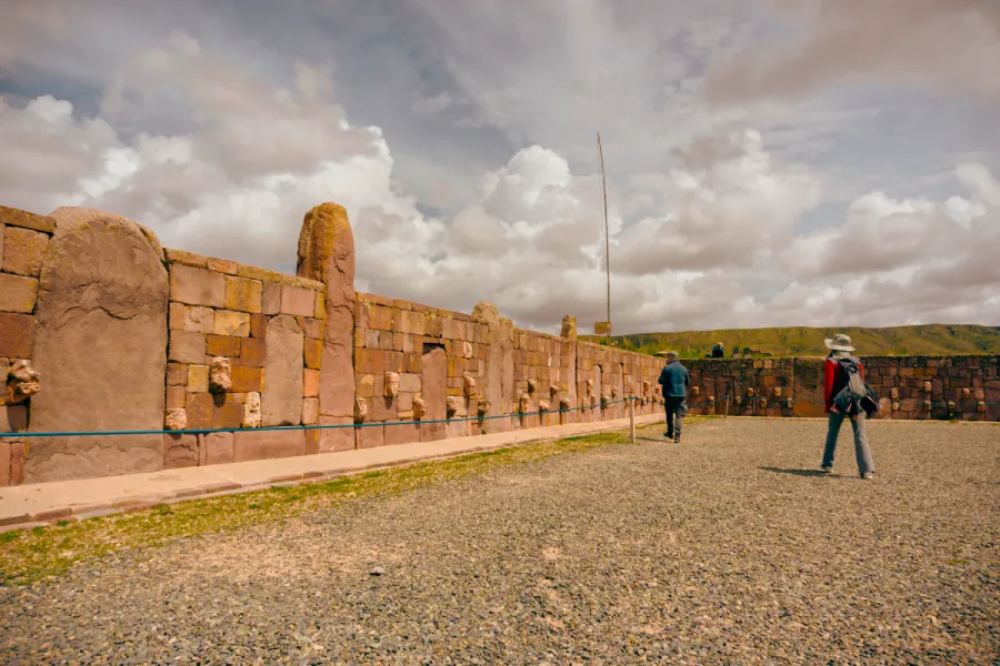 Visitors walking along the stone walls of the Tiwanaku archaeological site in Bolivia